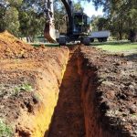A trench digger machine digging a trench.