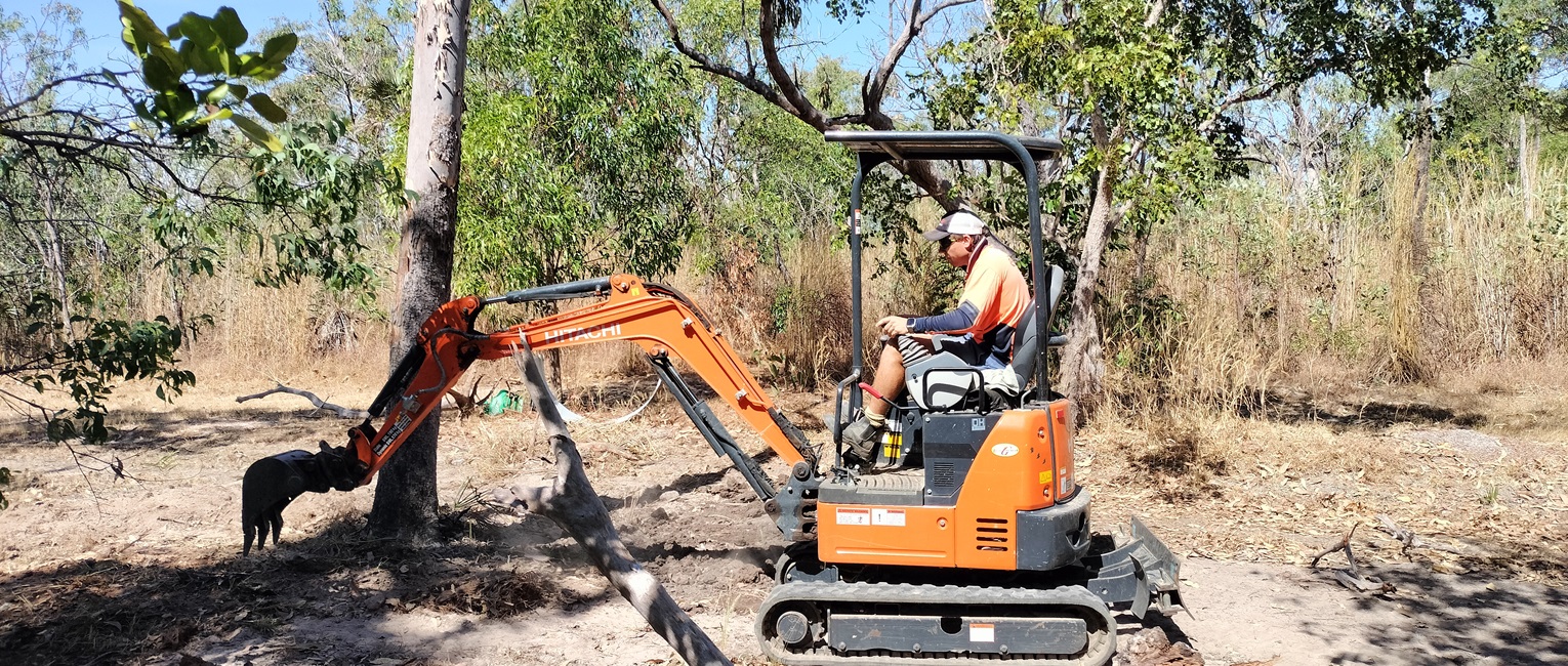 Mini excavator clearing land and vegetation on a Darwin block